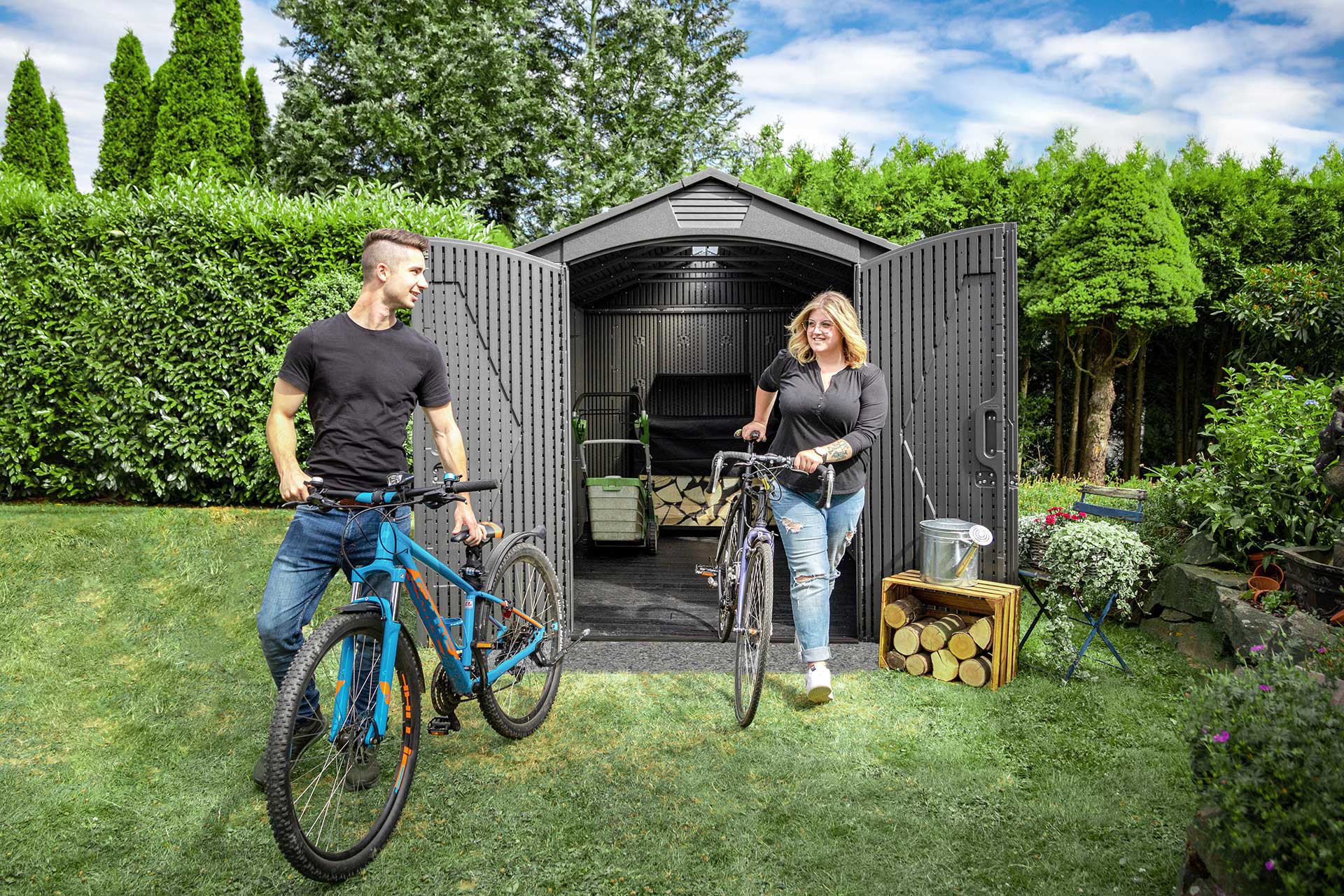 Zwei Personen mit Fahrrädern vor einem Lifetime Gerätehaus