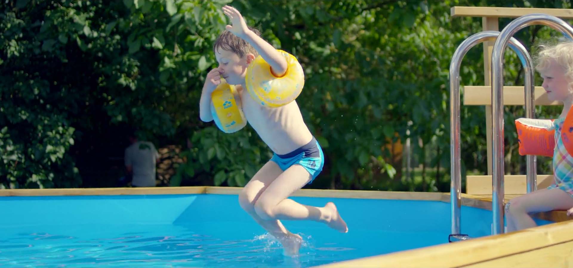 Kind springt in den Pool