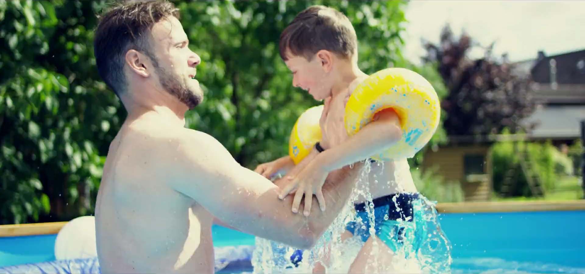 Vater im Pool nimmt seinen Sohn hoch